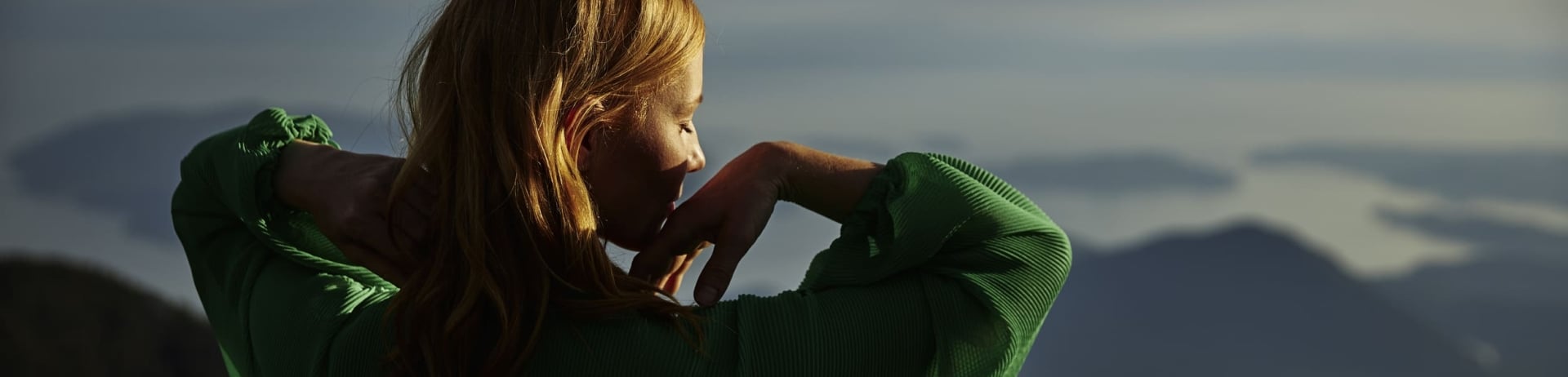 woman stretching by mountains