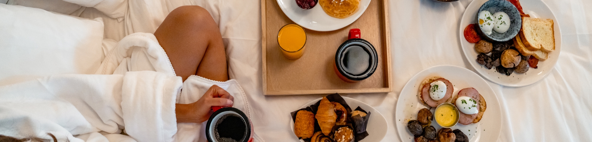 An overhead shot of room service breakfast on a bed at Fairmont Jasper Park Lodge.