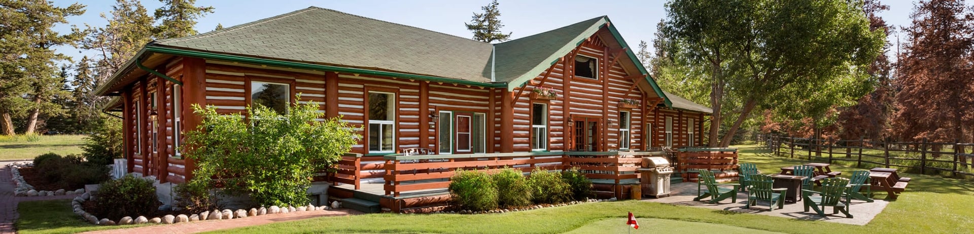 A view of the exterior and putting green at Milligan Signature Cabin at Fairmont Jasper Park Lodge.