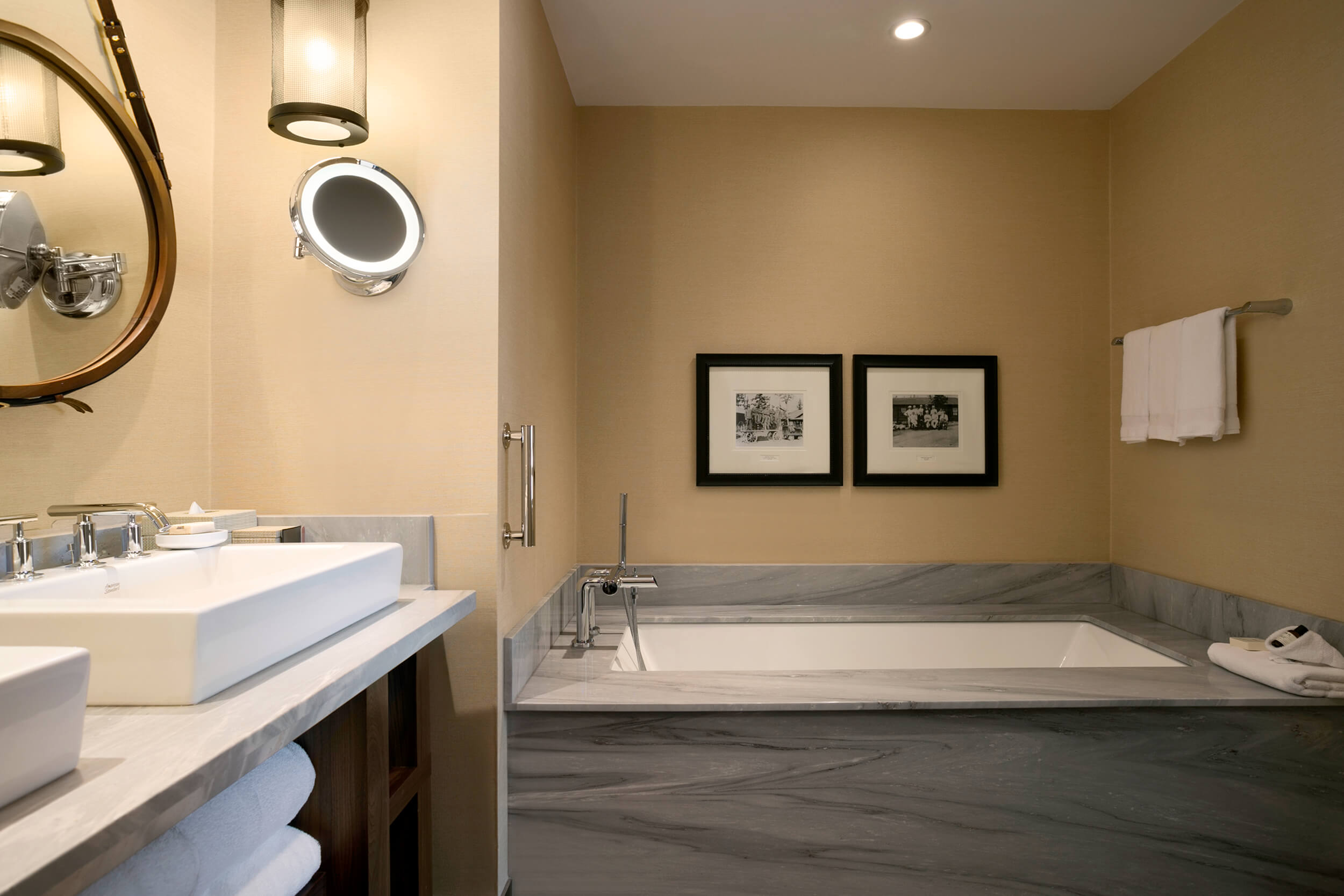 bathroom with twin sinks and a bath tub