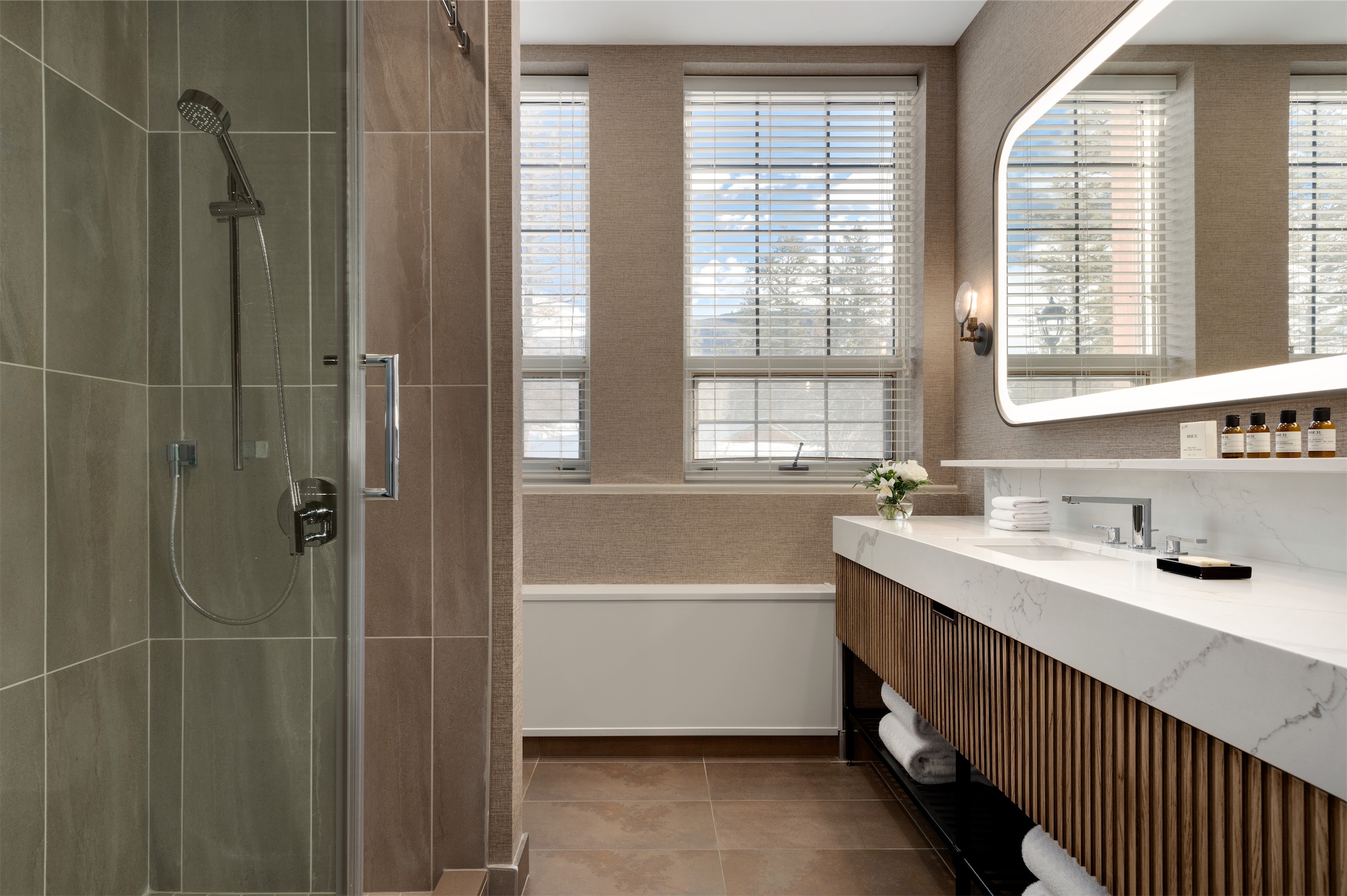 bathroom with long vanity and mirror with walk-in shower