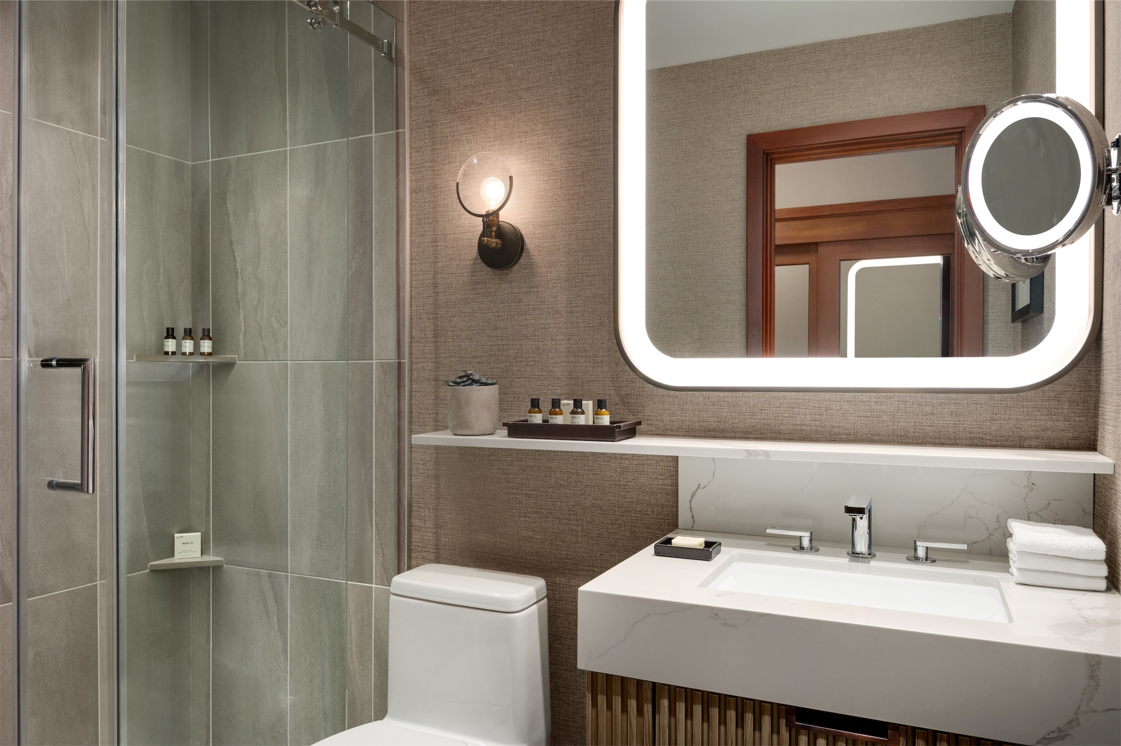 bathroom with walk-in shower and light-up mirror