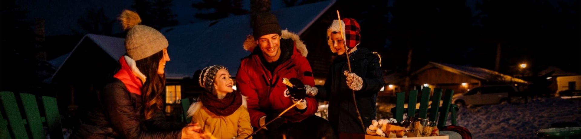 family sitting at a fire roasting marshmallows