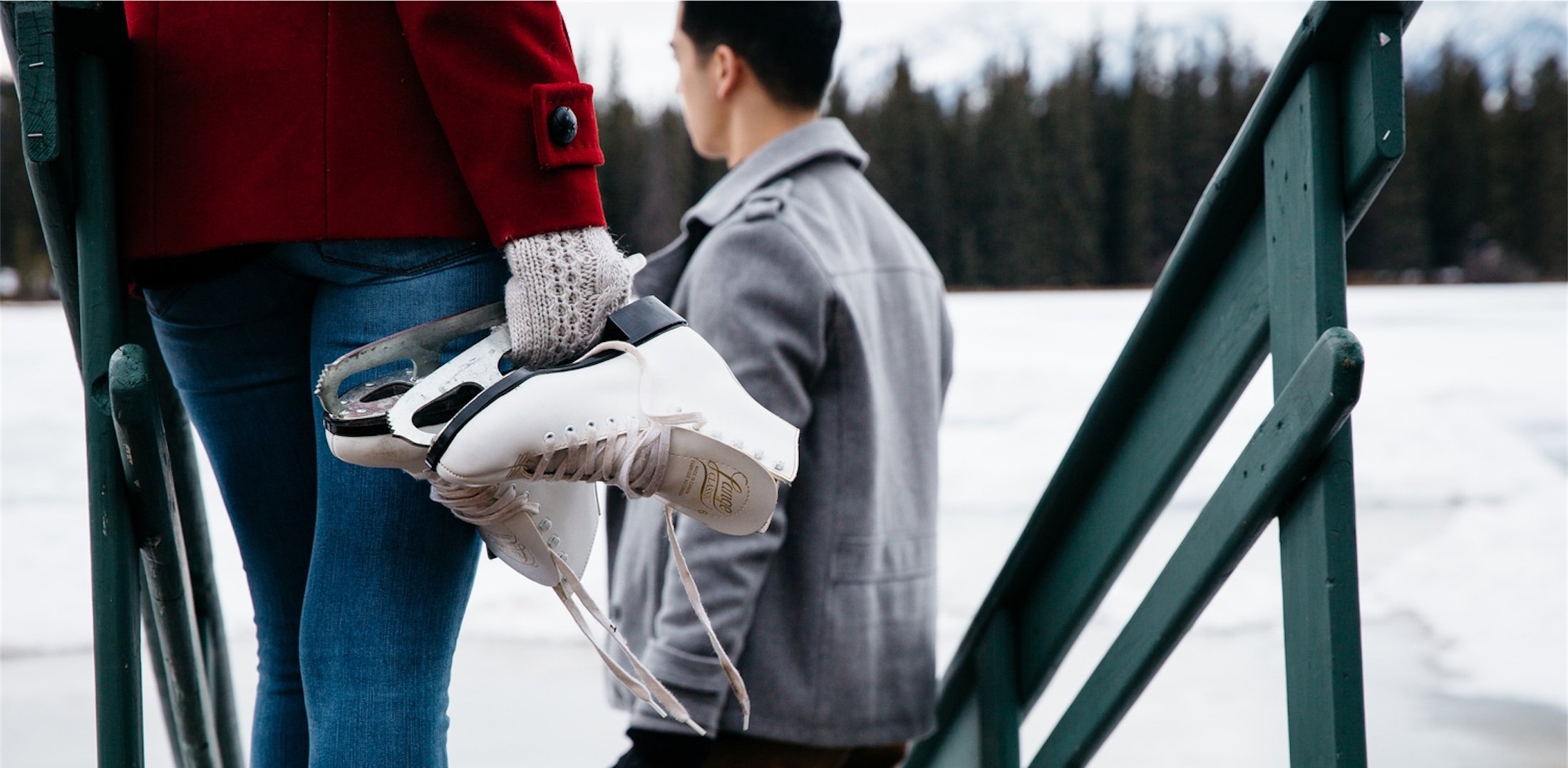 people holding skates down stairs to a frozen lake mildred at jasper park lodge
