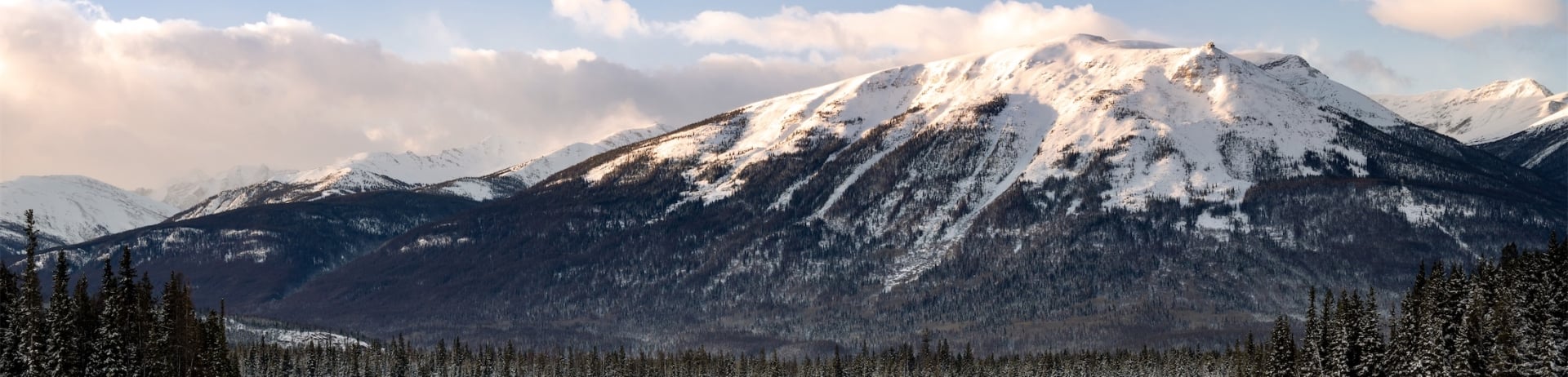 two adirondack chairs next to lake in winter