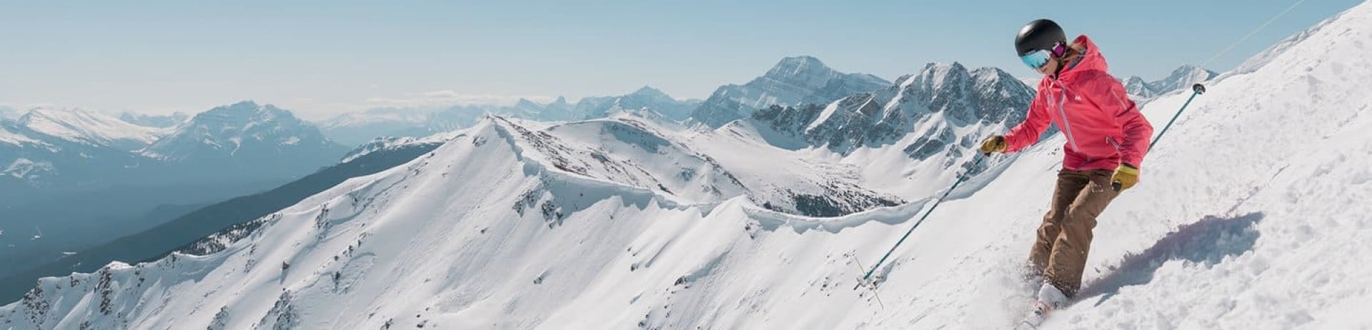 A skier carving down a snowy mountainside