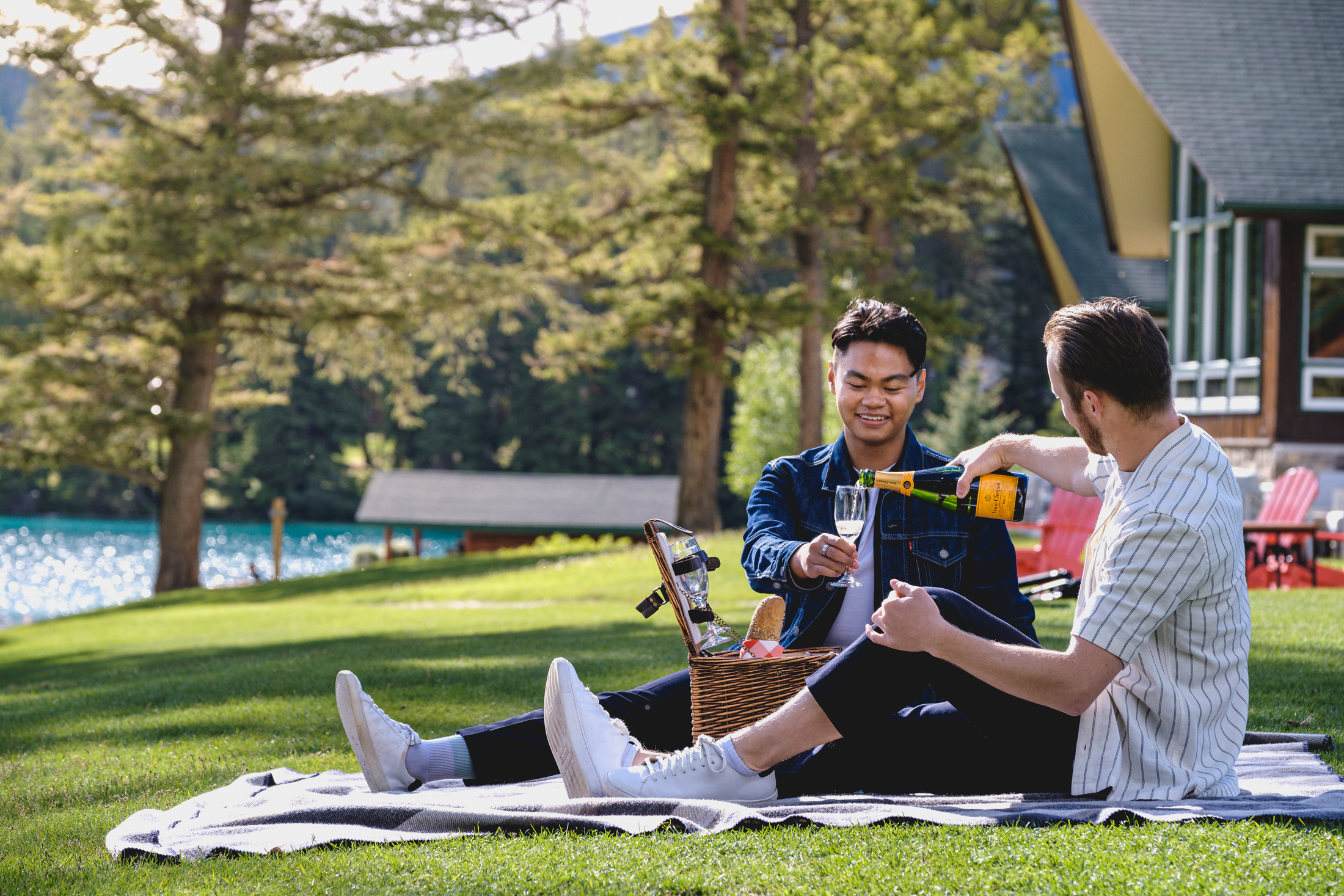 couple enjoying champagne and picnic by the lake