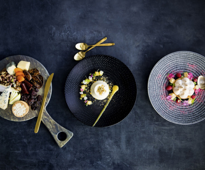 Three colourful plates of food on a dark table