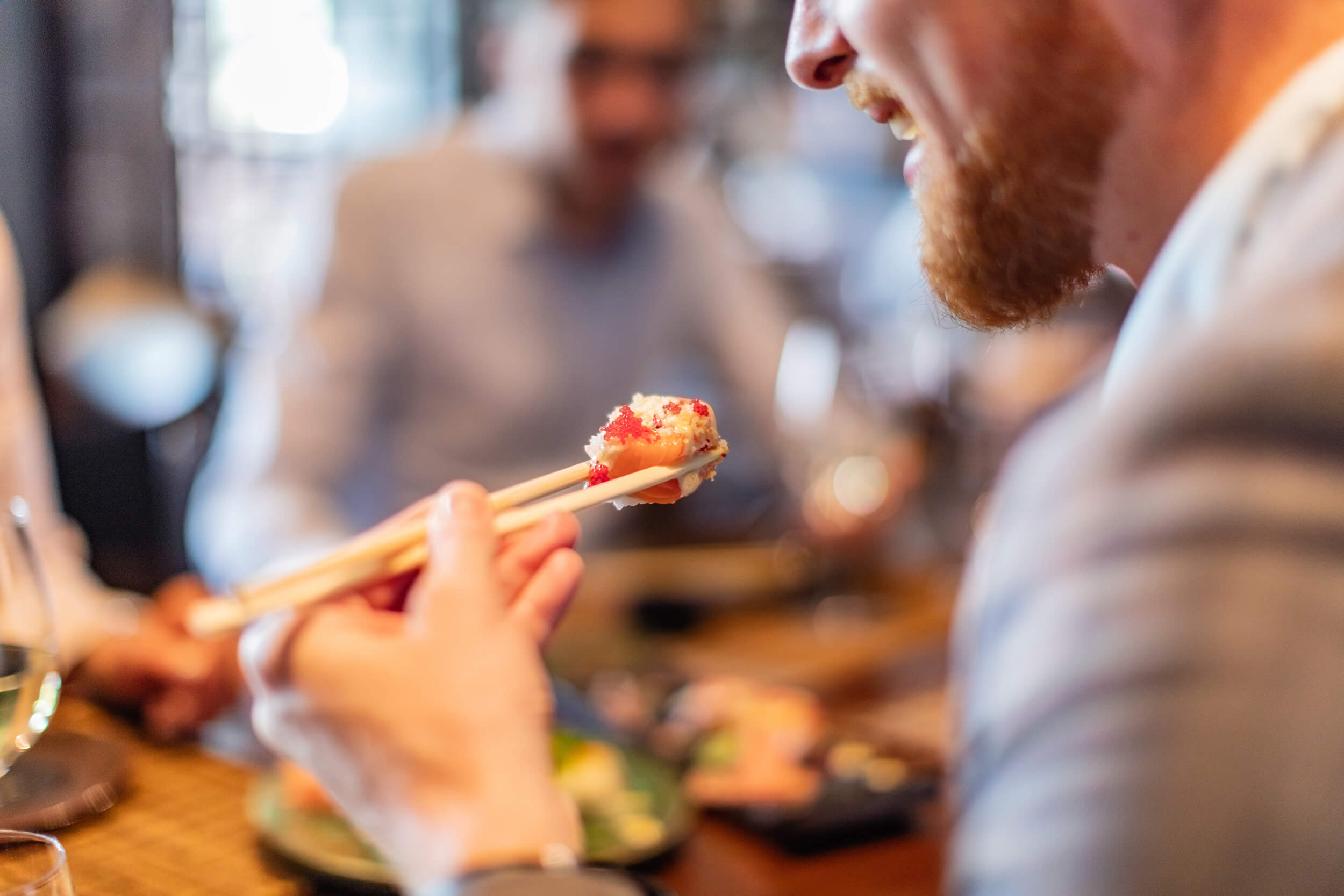 man with beard about to eat sushi