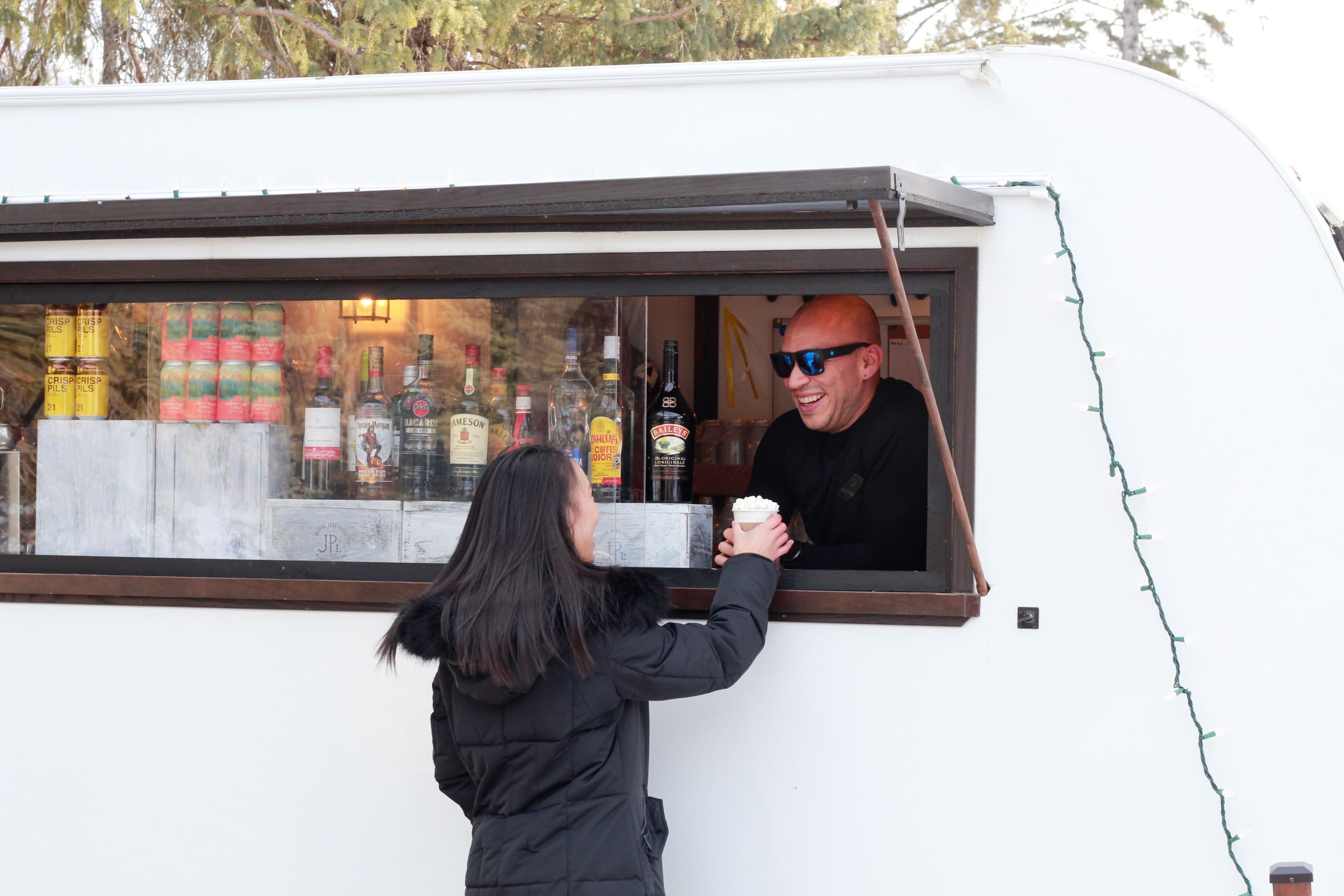 A woman getting a hot beverage from a food truck
