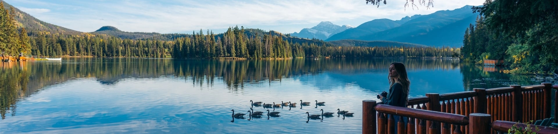 woman overlooking lake with her camera in hand