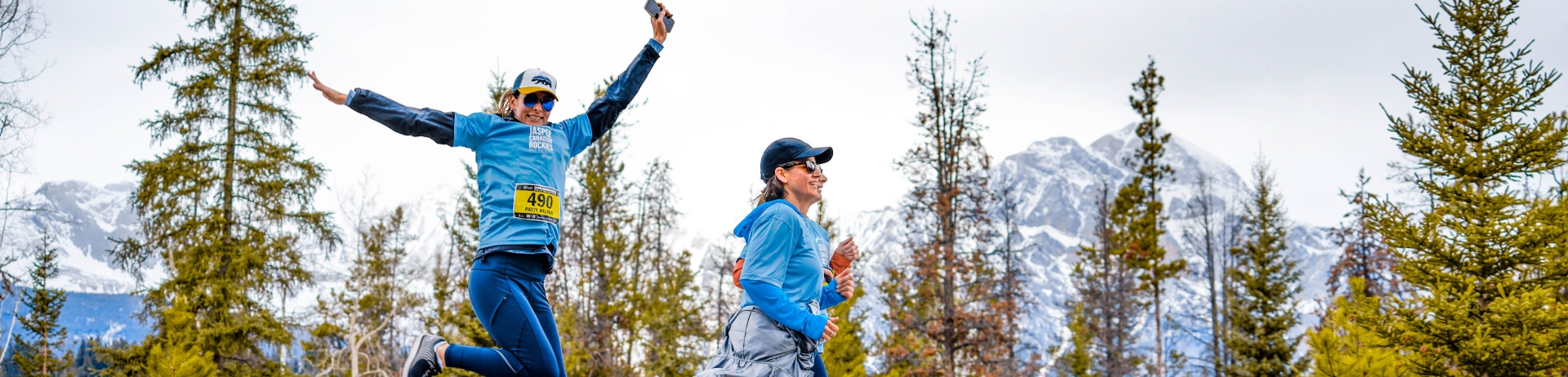 A group of people running on a path with moutnains in the background at the Jasper Half Marathon