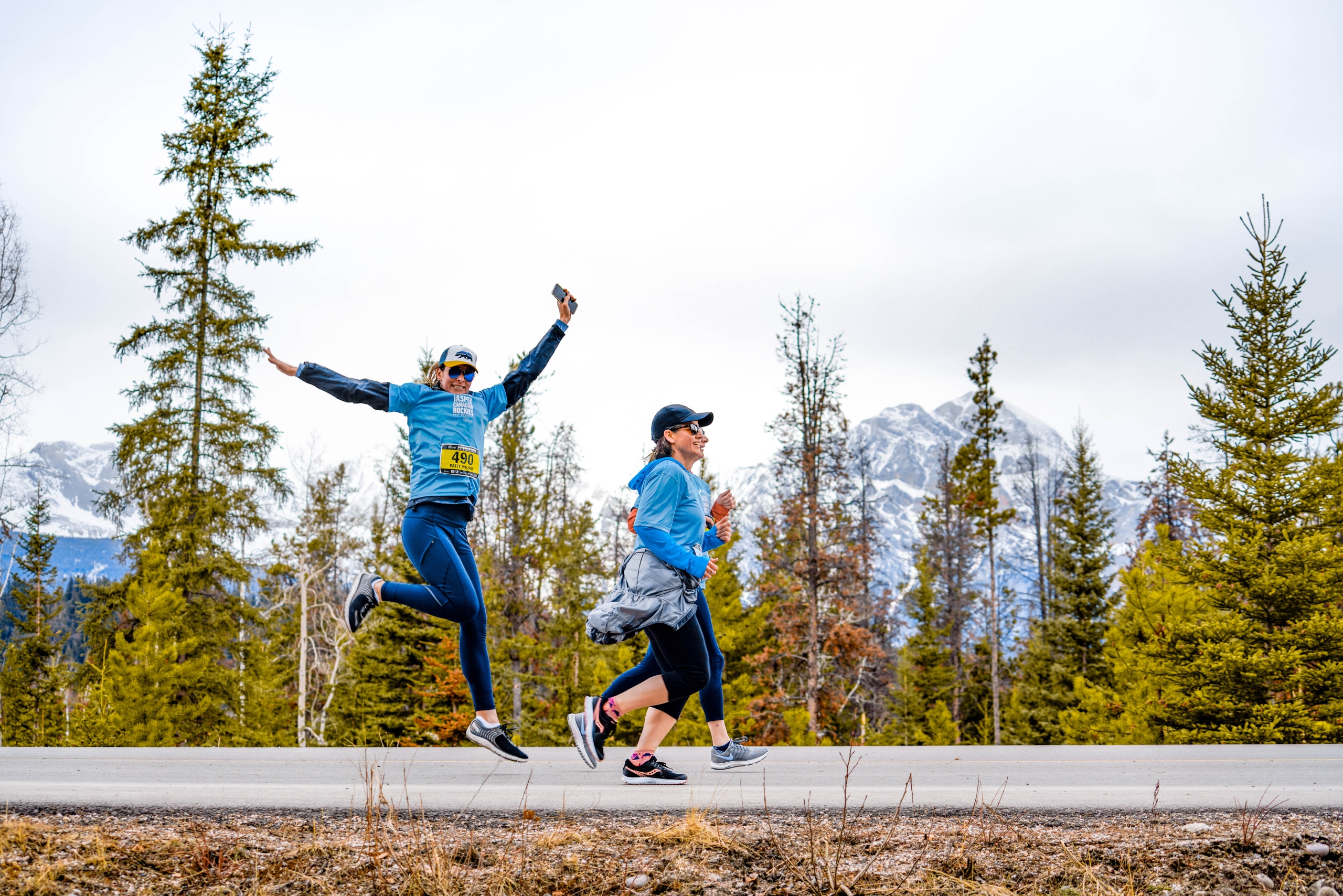 A group of people running on a path with moutnains in the background at the Jasper Half Marathon