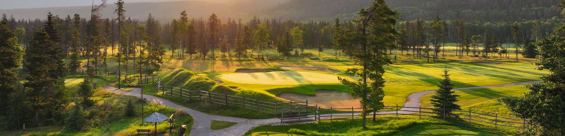 The sun rising behind the mountains on the Fairmont Jasper Park Lodge golf course.