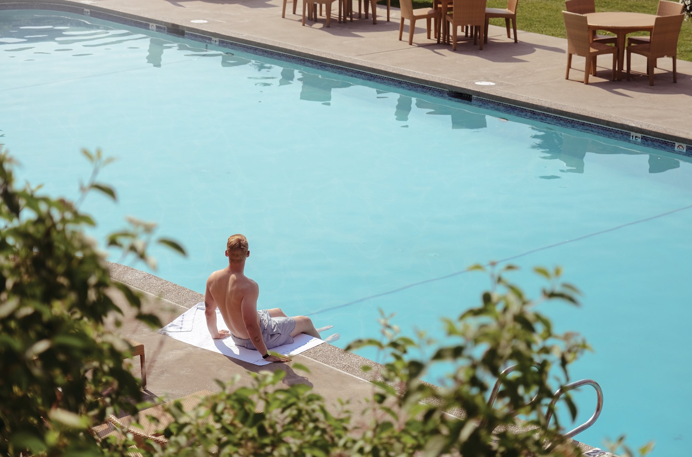 Man relaxing by the outdoor pool at Fairmont Jasper Park Lodge