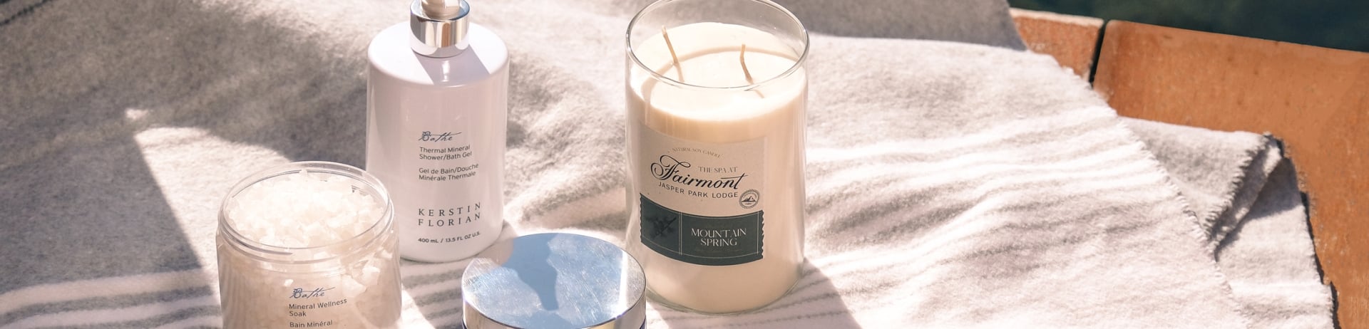 Fairmont Spa products scattered on a blanket with water in the background.