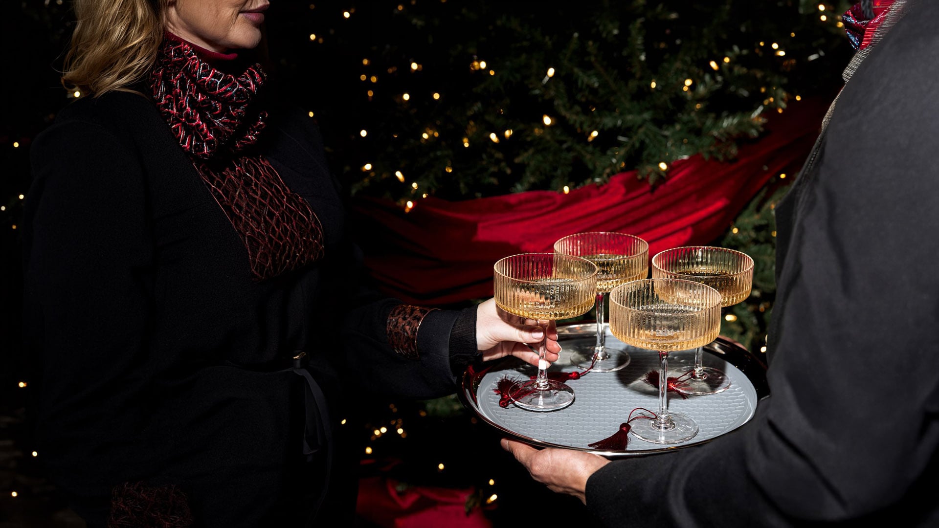 A person removing cocktails from a tray