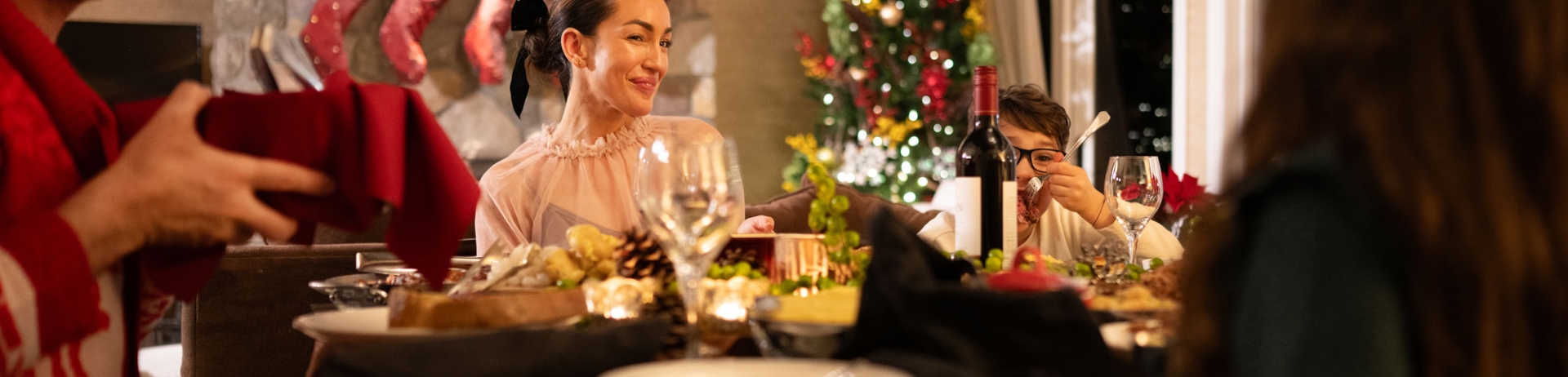 Family sitting down for a Christmas in Stanley Thompson Cabin at Fairmont Jasper Park Lodge.