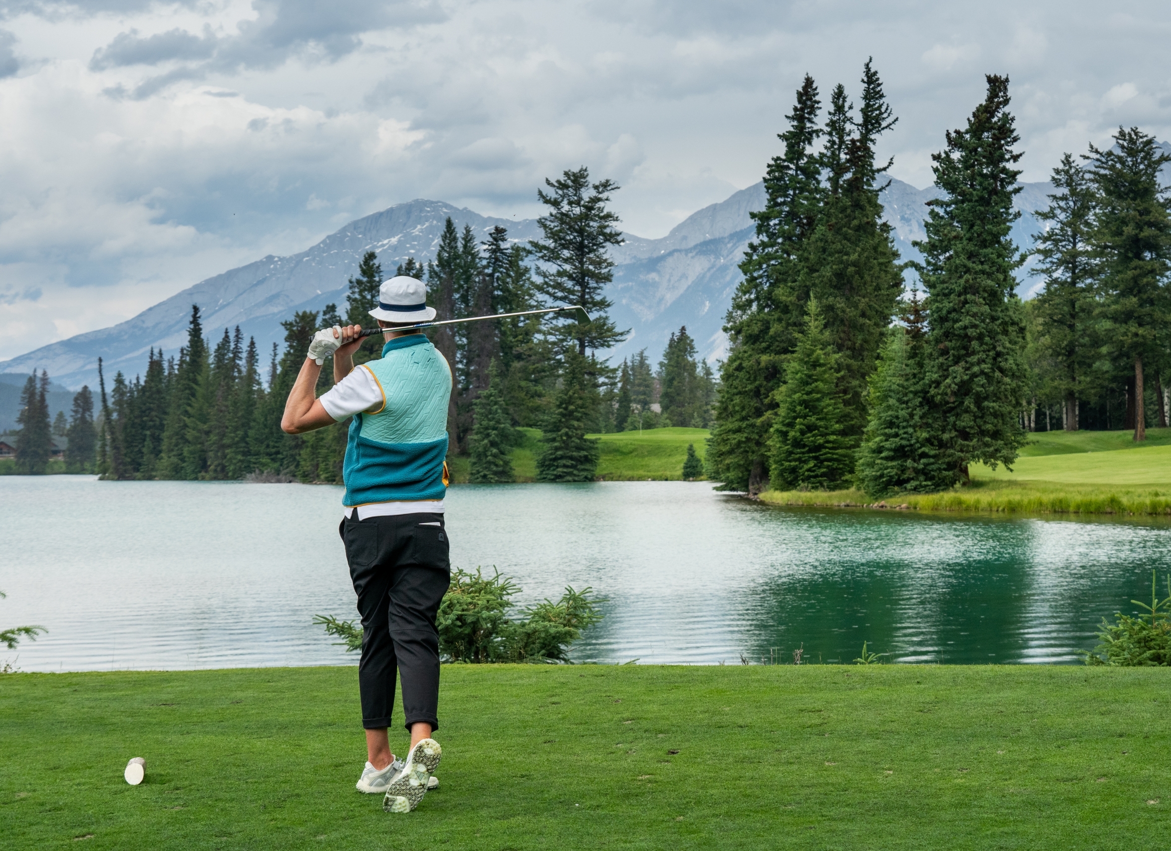Golfer watching ball on the course at Fairmont Jasper Park Lodge Golf Club