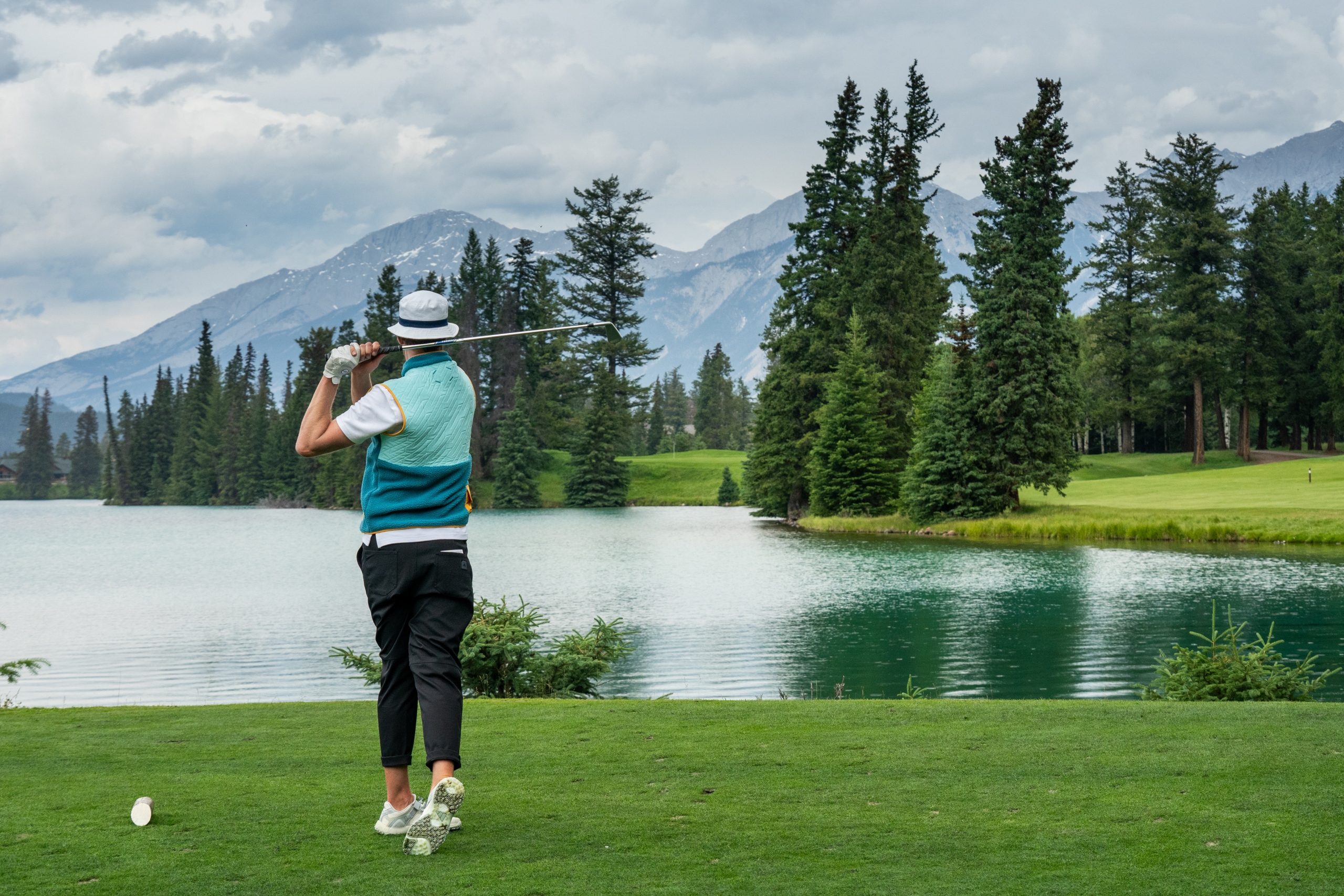 Golfer watching ball on the course at Fairmont Jasper Park Lodge Golf Club