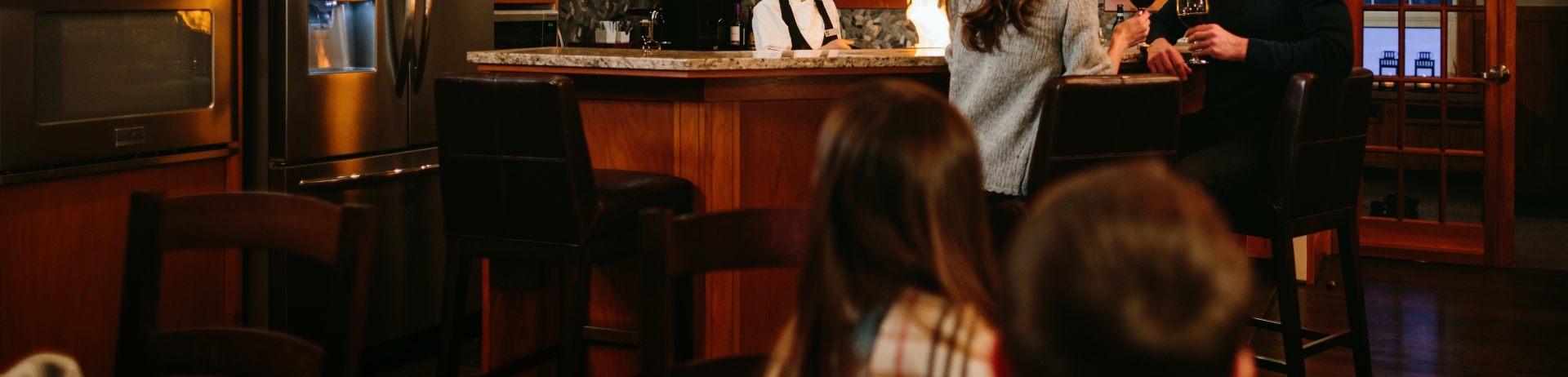 Family enjoying time in cabin with a chef preparing dinner