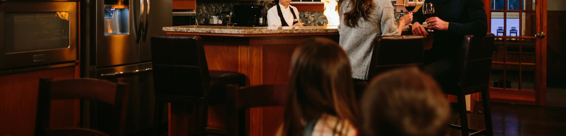 Family enjoying time in cabin with a chef preparing dinner