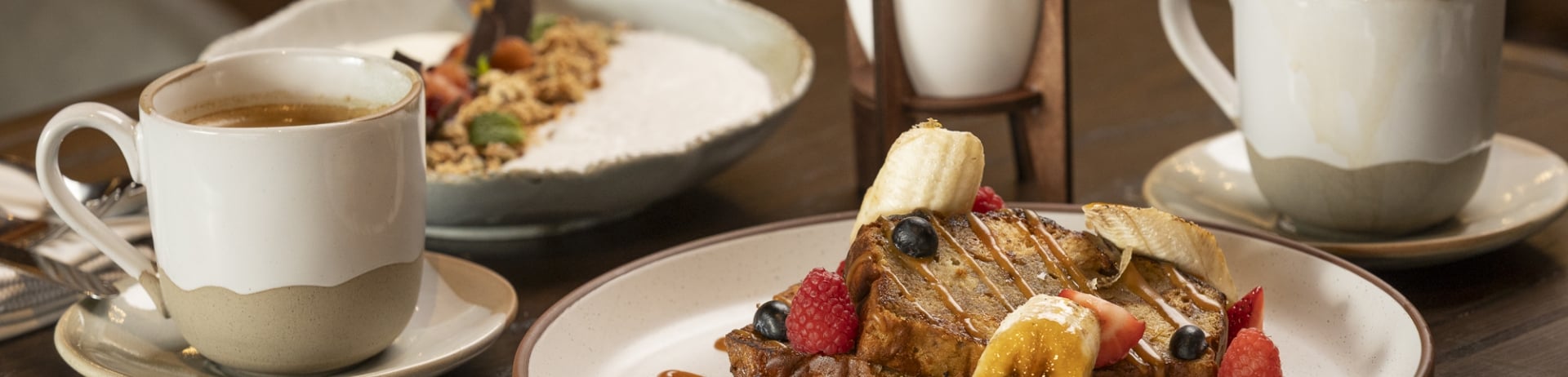 Banana Brûlée Toast adorned with Berries, Banana, Walnuts, Caramel Sauce, and Mascarpone Vanilla Whipped Cream. Berries | Banana | Walnuts, Caramel Sauce, and Mascarpone Vanilla Whipped Cream