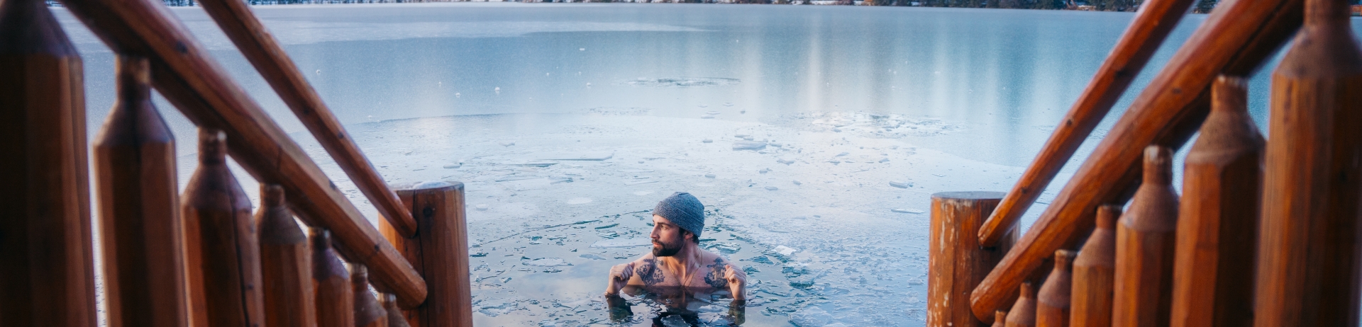 A person doing a cold plunge in an icy lakes in Jasper, Alberta, Canada