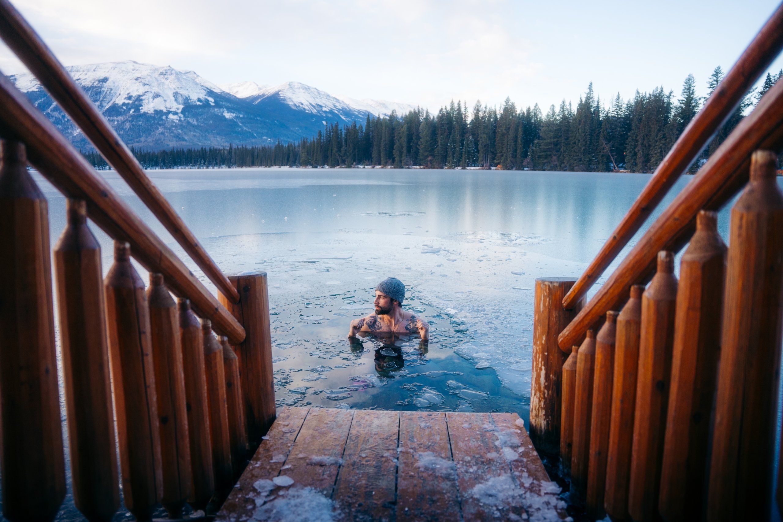 A person doing a cold plunge in an icy lakes in Jasper, Alberta, Canada