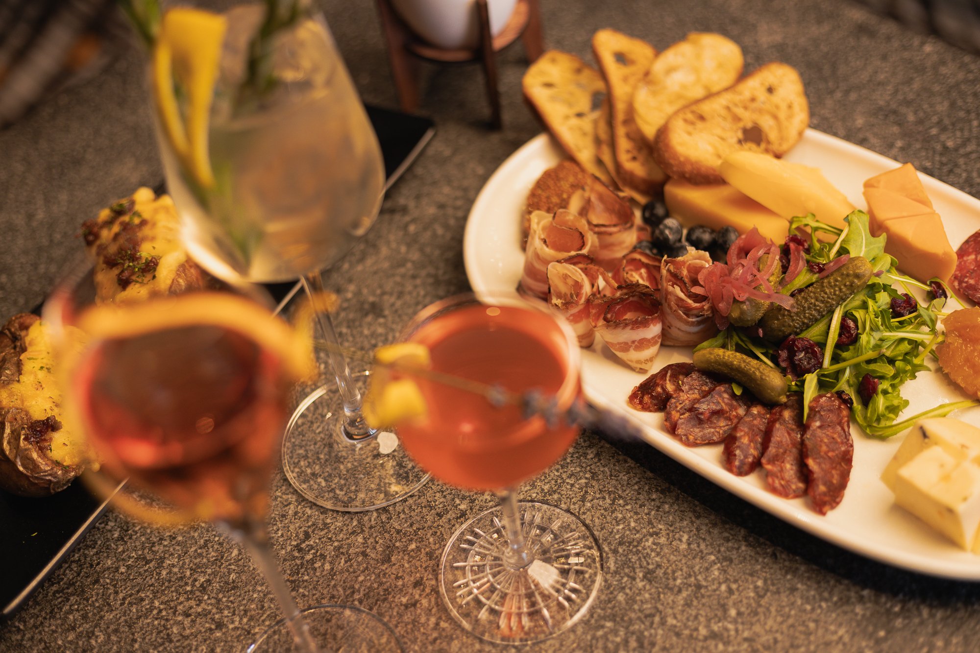 Cocktails and charcuterie plated on a table.