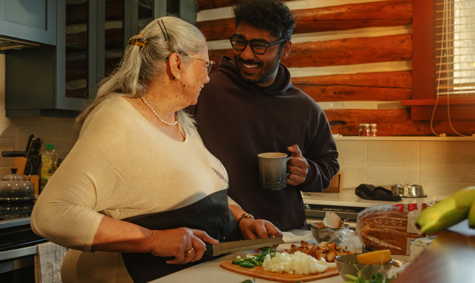 Adult mother and son cooking dinner together in a cabin