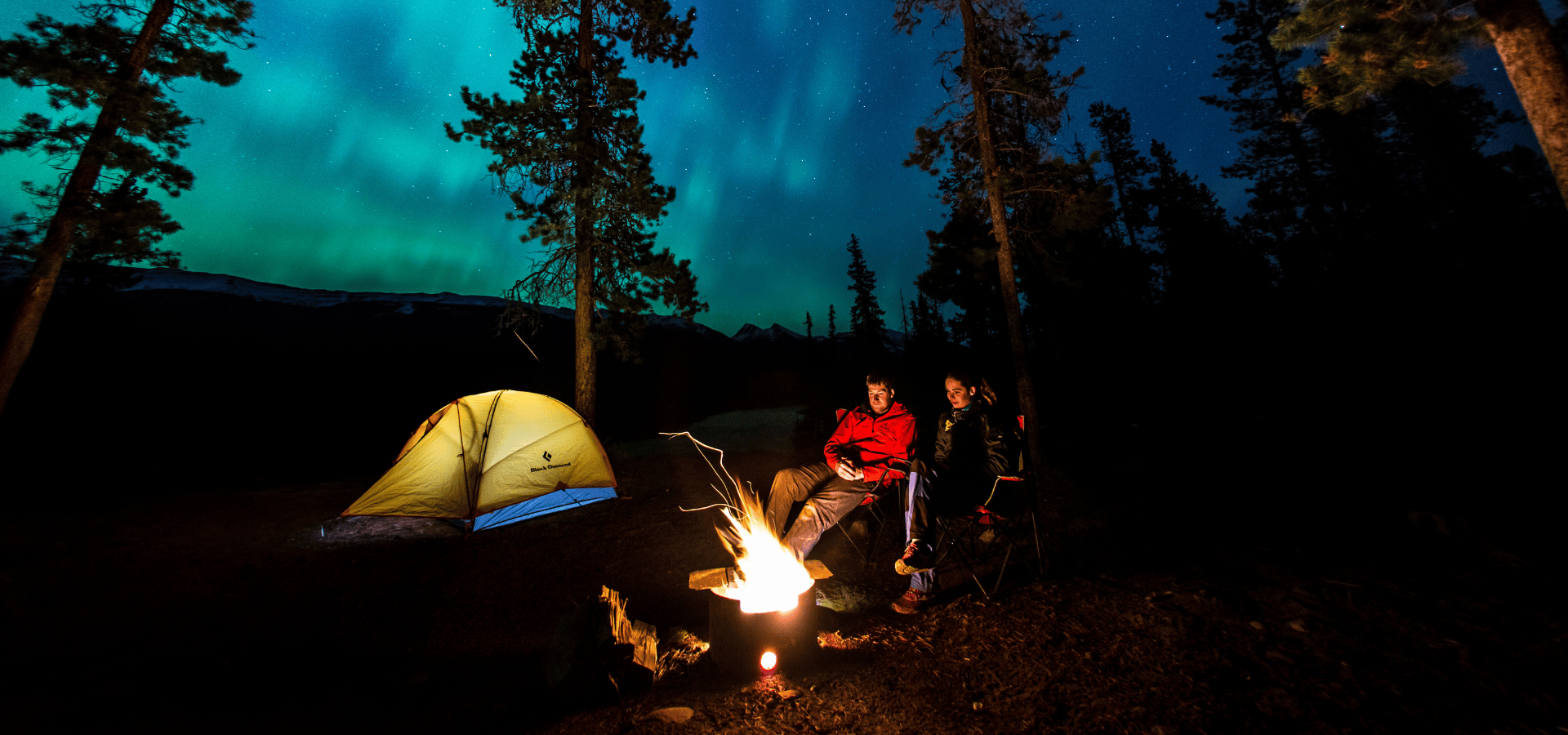 Couple camping under the northern lights