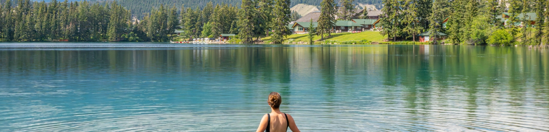 Young woman swimming in Lac Beauvert on a summer day.