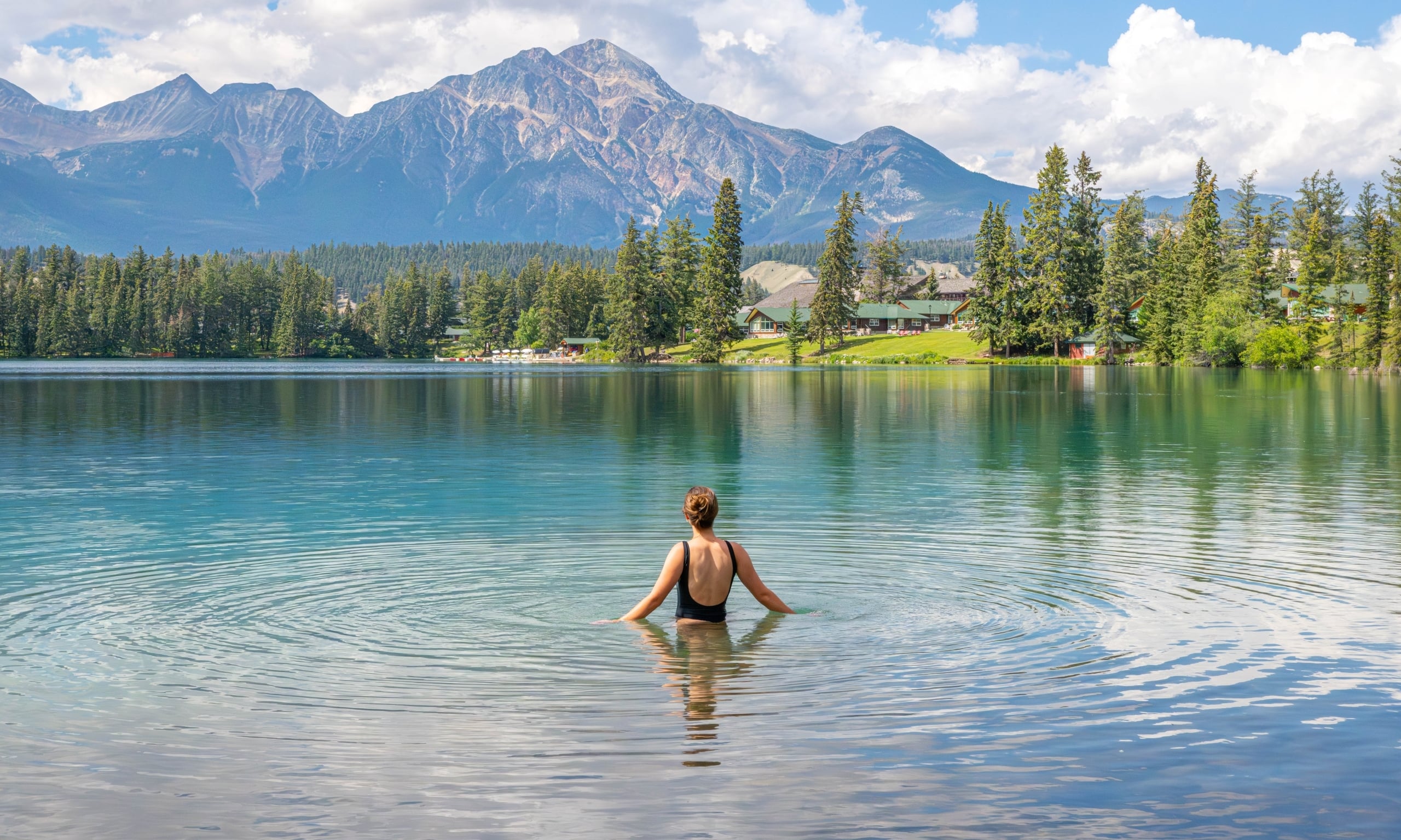 Young woman swimming in Lac Beauvert on a summer day.