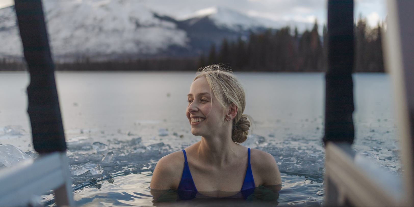 A woman smiling as she experiences a glacier plunge