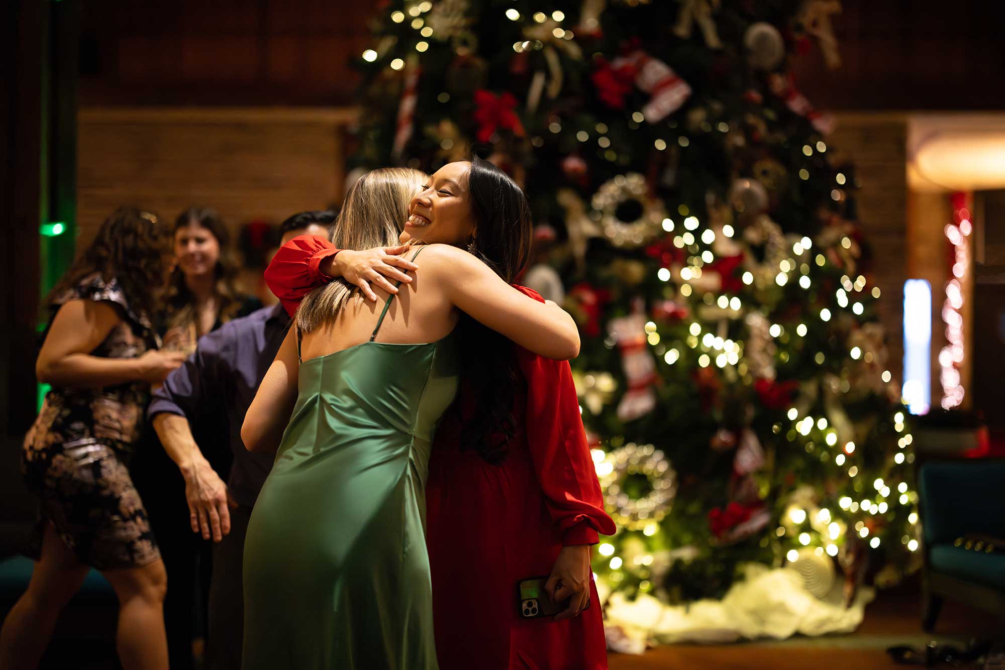 friends hugging at Christmas in November event at Fairmont Jasper Park Lodge