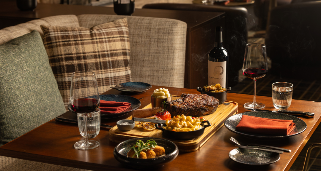 A table filled with food at a steakhouse.
