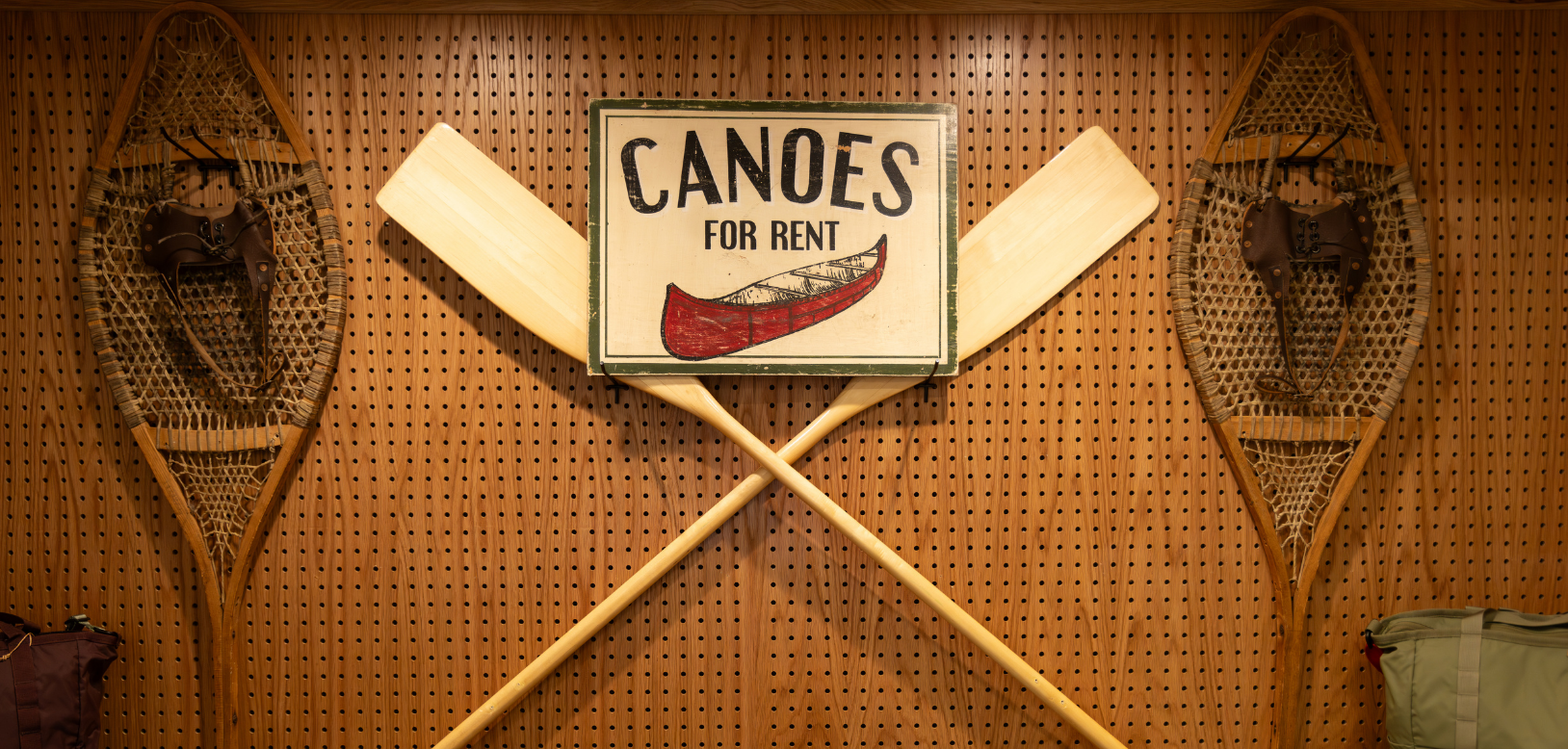 Two paddles crossed with a Canoe print in the centre.