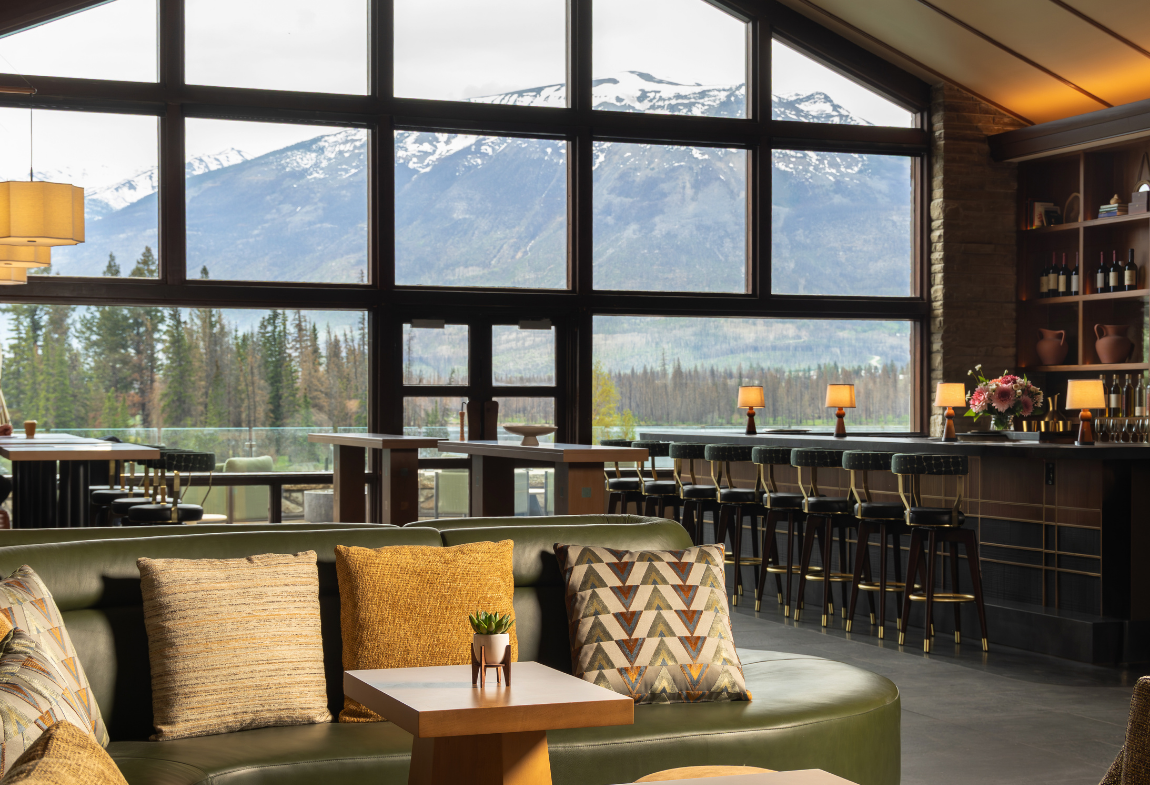 A bar in a lounge with a gorgeous mountain view.