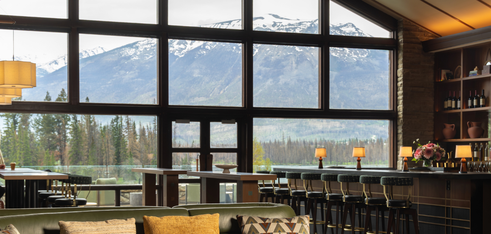 A bar in a lounge with a gorgeous mountain view.