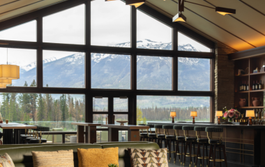 A bar in a lounge with a gorgeous mountain view.