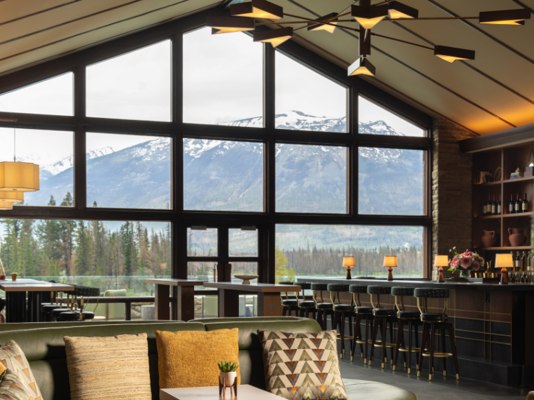 A bar in a lounge with a gorgeous mountain view.